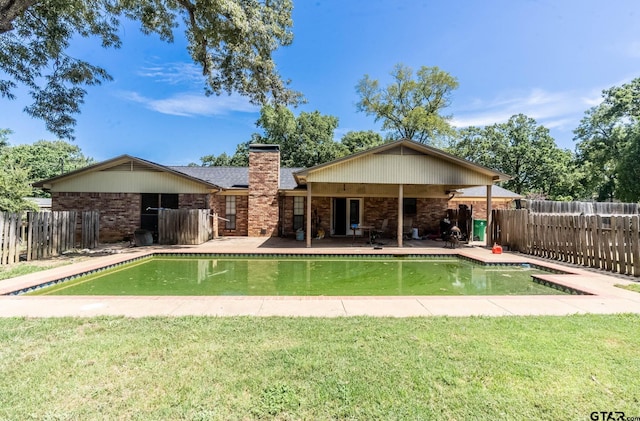 310 Windridge Rd, Palestine, TX 75801 - back of property featuring a chimney, brick siding, and a patio