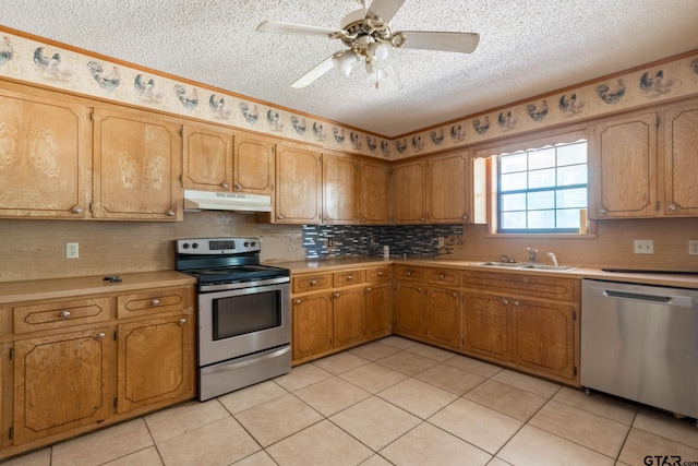 310 Windridge Rd, Palestine, TX 75801 - kitchen featuring appliances with stainless steel finishes, under cabinet range hood, a textured ceiling, light tile patterned floors, and decorative backsplash