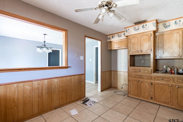 310 Windridge Rd, Palestine, TX 75801 - kitchen featuring wainscoting, a textured ceiling, a chandelier, light tile patterned floors, and a ceiling fan
