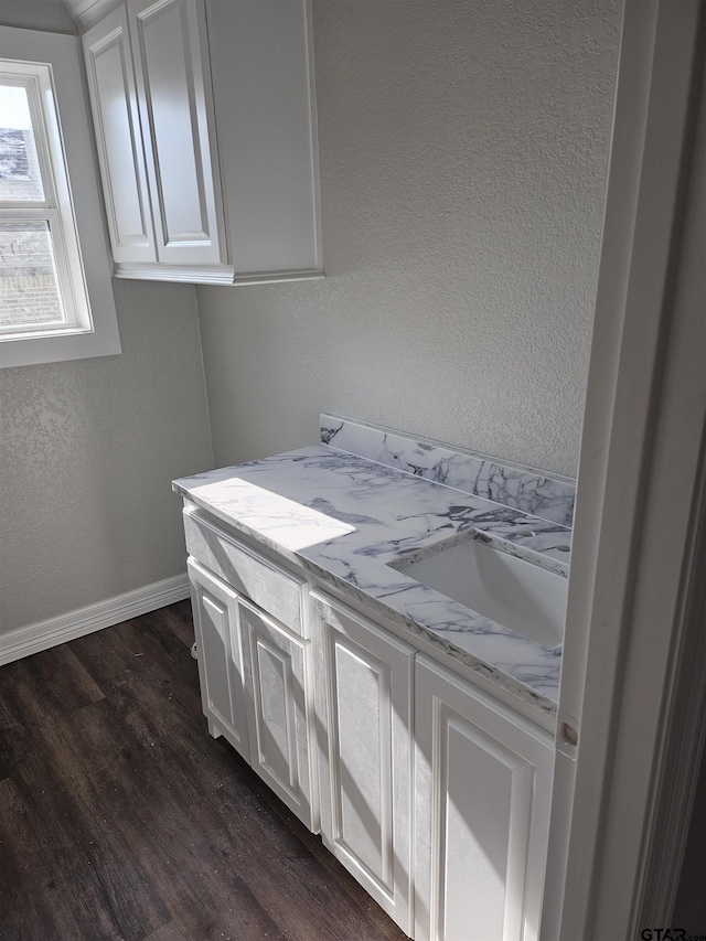 105 Johnston St, Arp, TX 75750 - laundry room with dark wood-type flooring, a sink, baseboards, and a textured wall