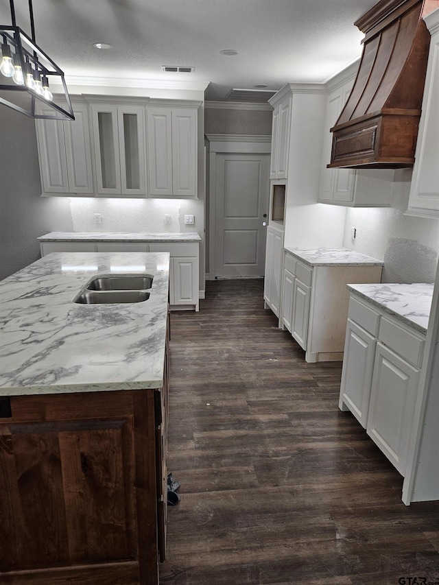 105 Johnston St, Arp, TX 75750 - kitchen with light stone countertops, dark wood-style flooring, crown molding, pendant lighting, and custom range hood