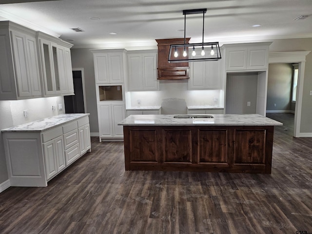 105 Johnston St, Arp, TX 75750 - kitchen with a kitchen island, dark wood finished floors, glass insert cabinets, ornamental molding, and baseboards