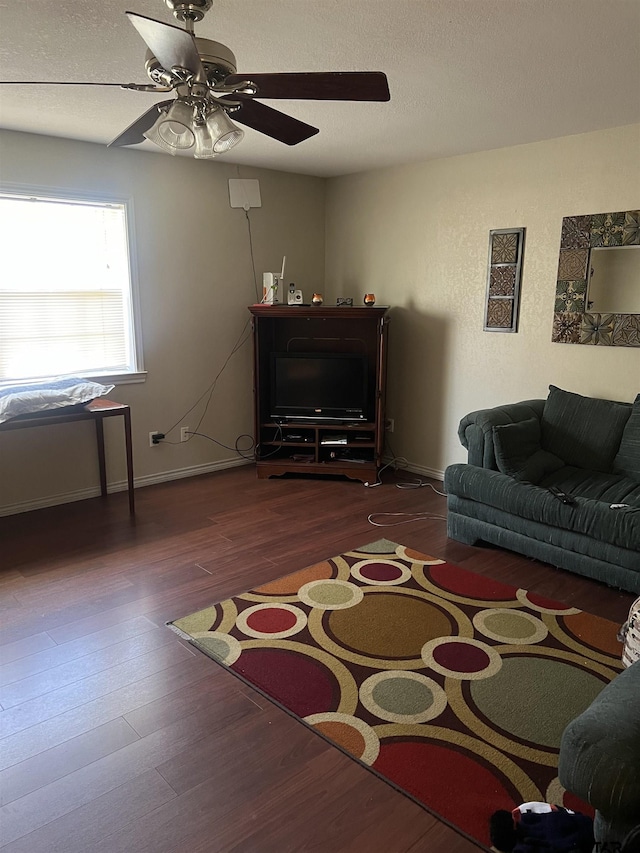 living room with dark hardwood / wood-style flooring, ceiling fan, and a textured ceiling