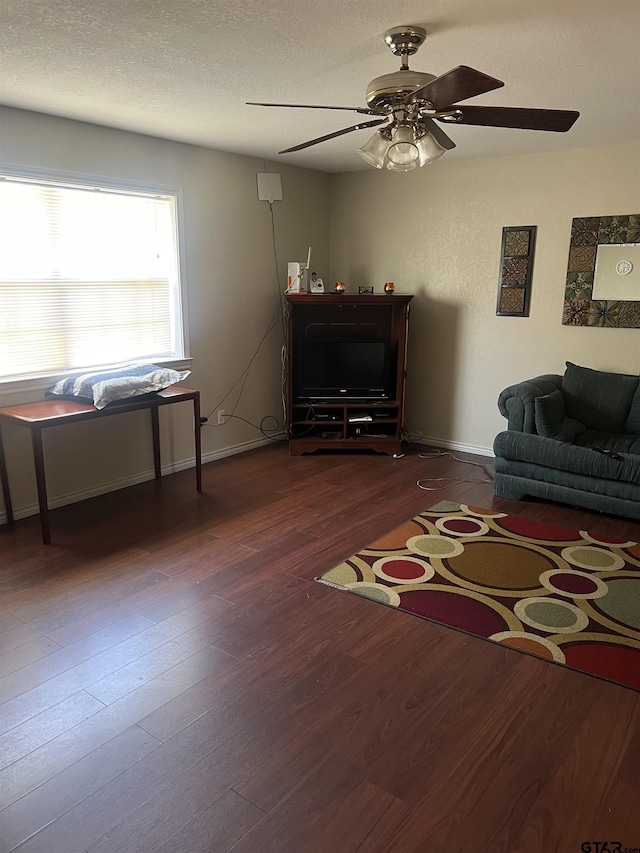 interior space with ceiling fan, dark hardwood / wood-style floors, and a textured ceiling