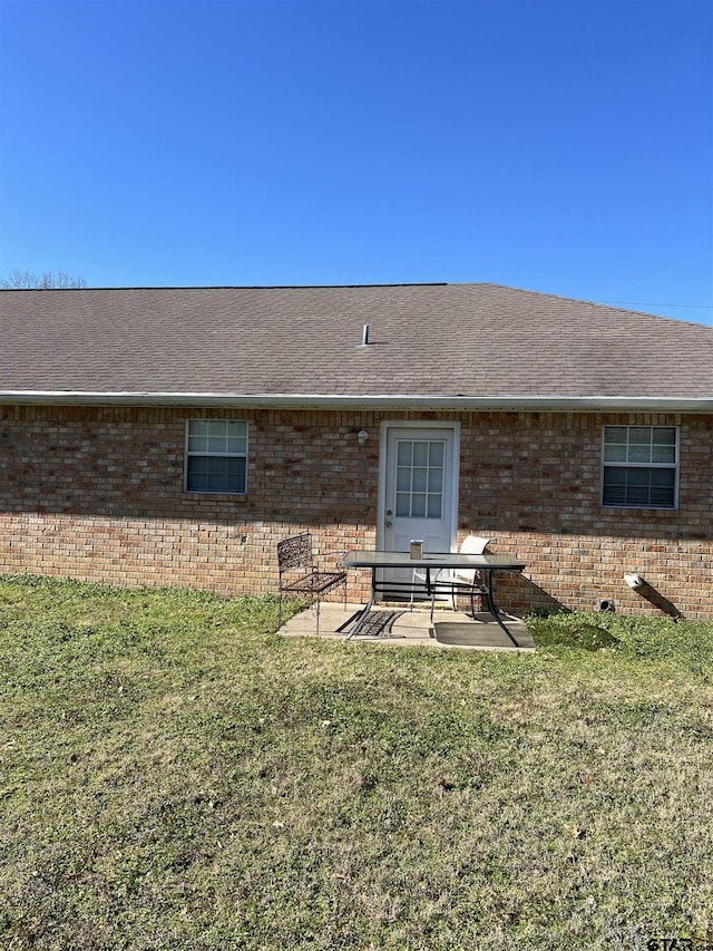 rear view of property featuring a yard and a patio