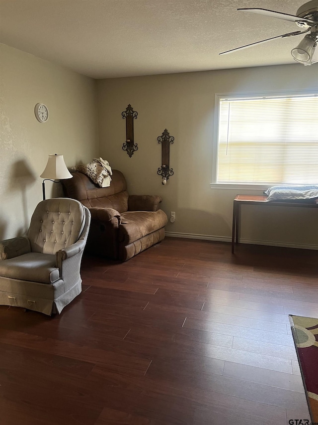 sitting room with ceiling fan, hardwood / wood-style floors, and a textured ceiling