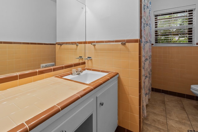 bathroom featuring vanity, tile patterned flooring, toilet, and tile walls