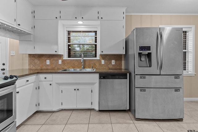 kitchen with stainless steel appliances, white cabinets, sink, and light tile patterned floors