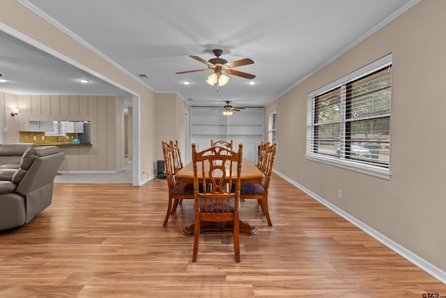 dining room with light hardwood / wood-style floors, ceiling fan, sink, and ornamental molding