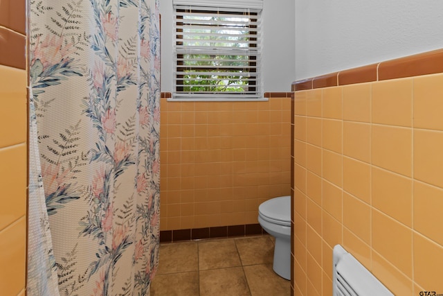 bathroom with toilet, a shower with curtain, tile walls, and tile patterned flooring