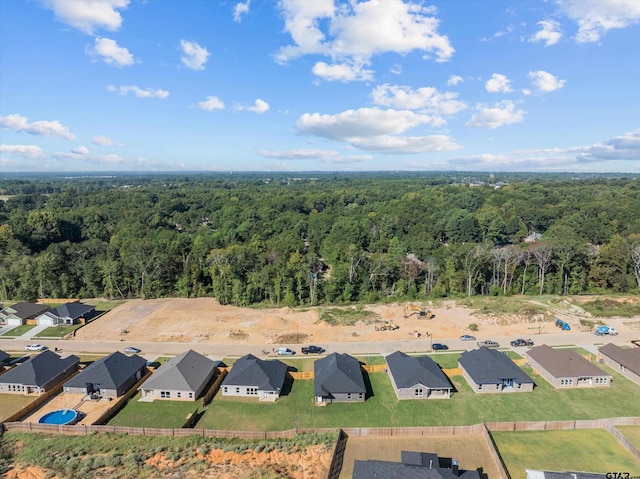 drone / aerial view featuring a forest view and a residential view