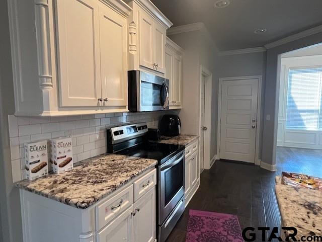 kitchen featuring white cabinets, decorative backsplash, light stone counters, appliances with stainless steel finishes, and dark hardwood / wood-style flooring