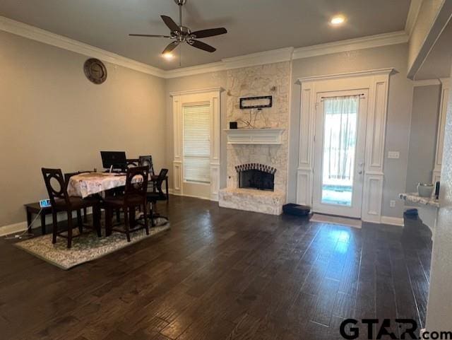 dining area featuring ceiling fan, a fireplace, dark wood-type flooring, and ornamental molding