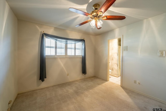 spare room featuring light carpet and a ceiling fan