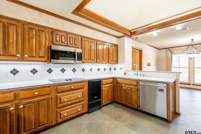 kitchen with stainless steel appliances, a peninsula, a sink, and brown cabinets