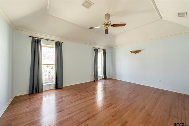 spare room featuring light wood finished floors, visible vents, baseboards, lofted ceiling, and ceiling fan