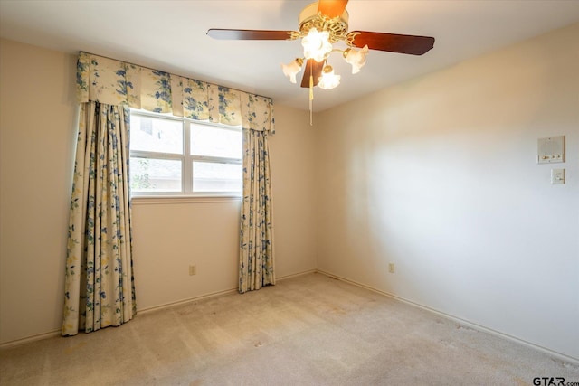 carpeted spare room featuring ceiling fan