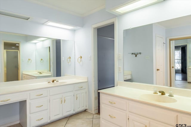 bathroom with a stall shower, vanity, ornamental molding, and tile patterned floors