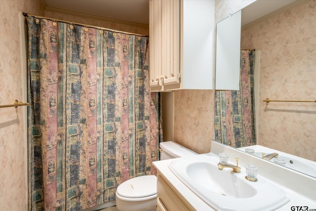 bathroom with toilet, wallpapered walls, and vanity