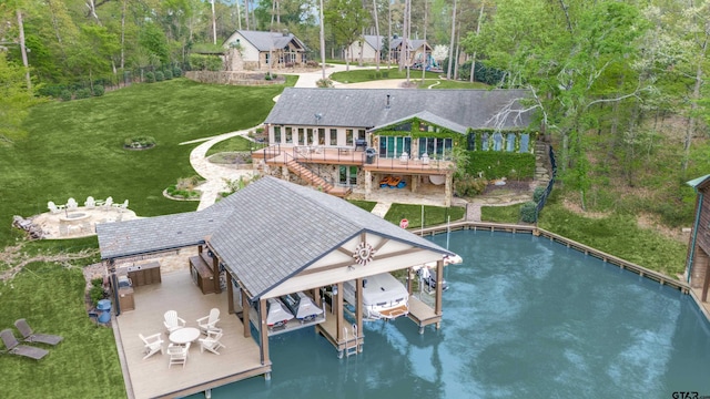 exterior space featuring a carport, an outdoor fire pit, a yard, boat lift, and a wooden deck