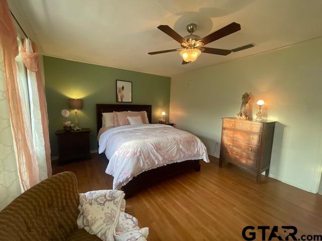 bedroom featuring ceiling fan and dark wood-type flooring