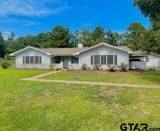 ranch-style house with a carport and a front yard