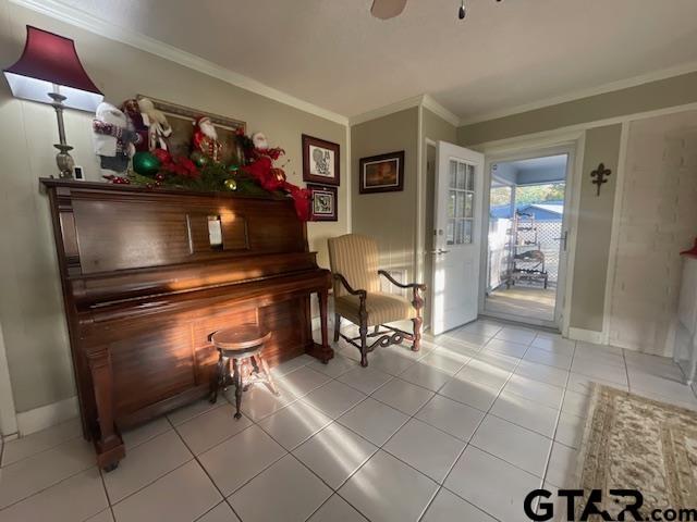 miscellaneous room with light tile patterned floors, ceiling fan, and crown molding