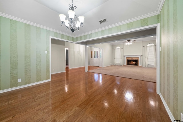 unfurnished living room with crown molding, visible vents, wood finished floors, and a fireplace