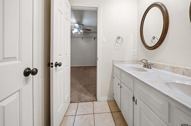 bathroom featuring ceiling fan, double vanity, a sink, and tile patterned flooring