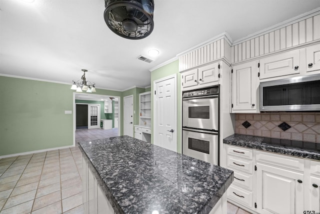 kitchen with a chandelier, appliances with stainless steel finishes, ornamental molding, and visible vents