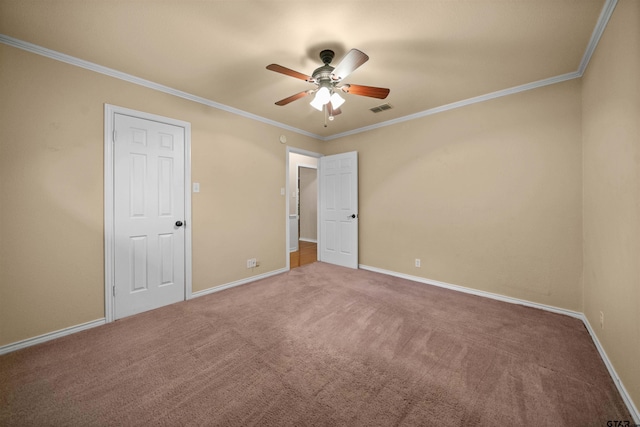 unfurnished bedroom featuring visible vents, baseboards, ceiling fan, crown molding, and carpet floors