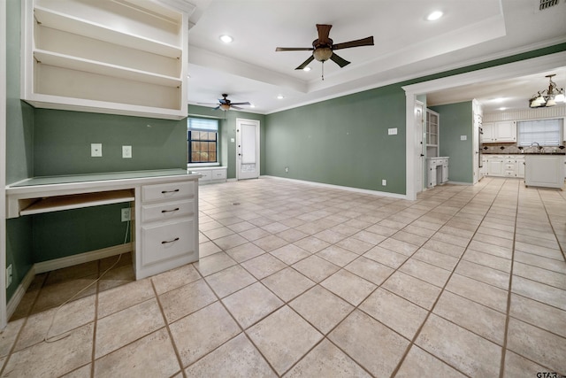 unfurnished living room with a tray ceiling, crown molding, ceiling fan with notable chandelier, and recessed lighting