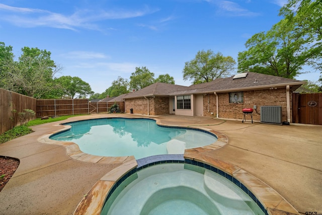 view of pool featuring a patio area, a pool with connected hot tub, central AC, and a fenced backyard