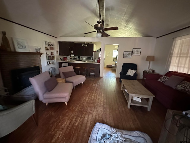 living room with a brick fireplace, vaulted ceiling, built in shelves, dark hardwood / wood-style floors, and ceiling fan