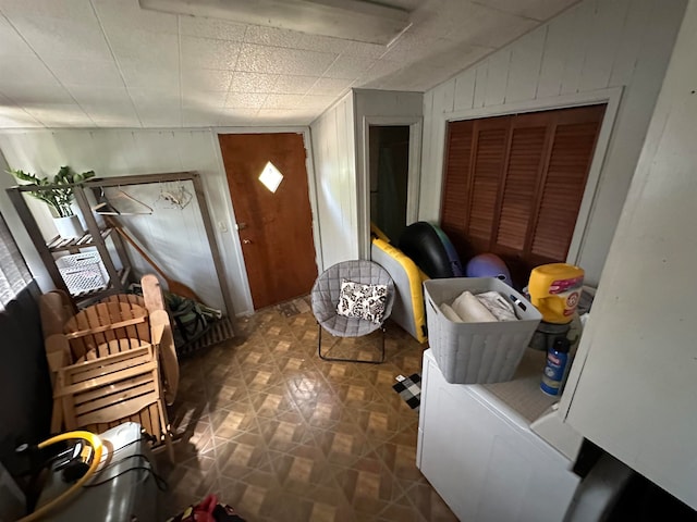 foyer entrance with lofted ceiling and wooden walls