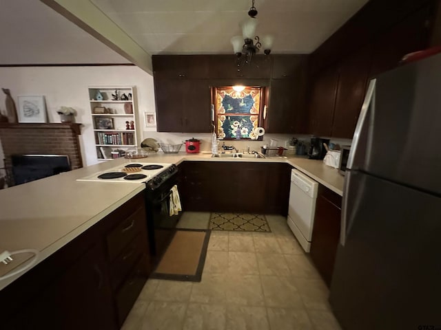 kitchen featuring sink, an inviting chandelier, a fireplace, white appliances, and dark brown cabinets