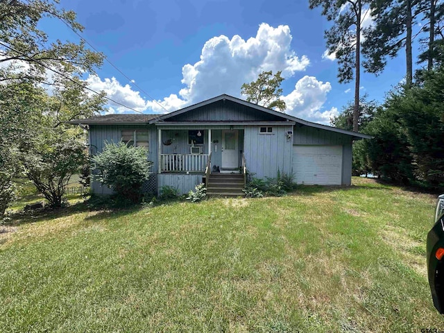 view of front of property featuring a front lawn, a garage, and a porch