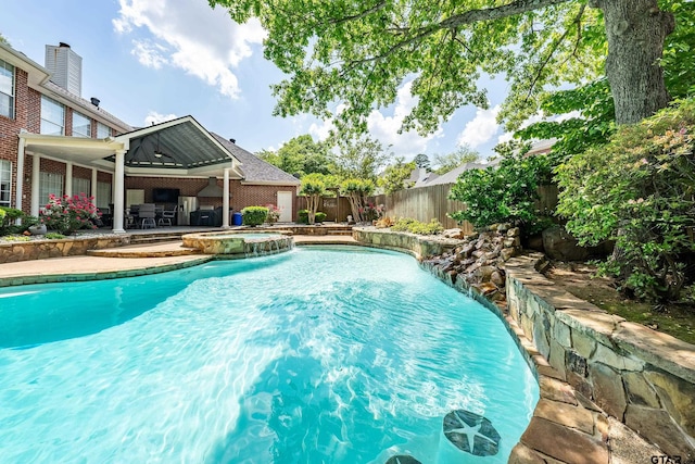 view of swimming pool with a pool with connected hot tub, a fenced backyard, and a patio