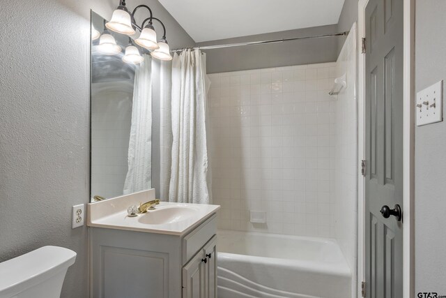 bathroom featuring shower / bath combo, toilet, a textured wall, and vanity