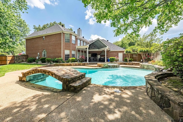 view of pool with a fenced backyard, a pool with connected hot tub, and a patio