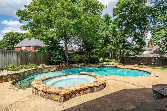 view of swimming pool featuring a fenced backyard, a patio, and a pool with connected hot tub