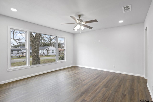 spare room featuring dark wood-style floors, recessed lighting, visible vents, and baseboards