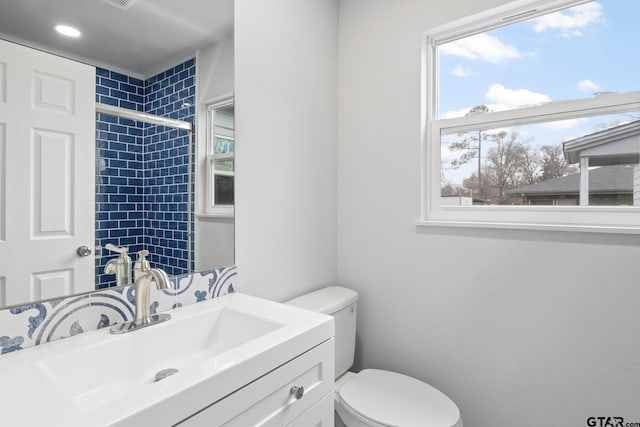 bathroom featuring toilet, a tile shower, and vanity