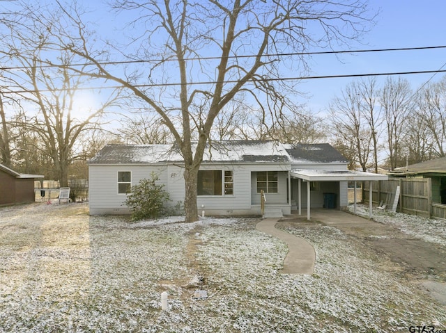 view of front of home with crawl space, fence, a carport, and roof with shingles