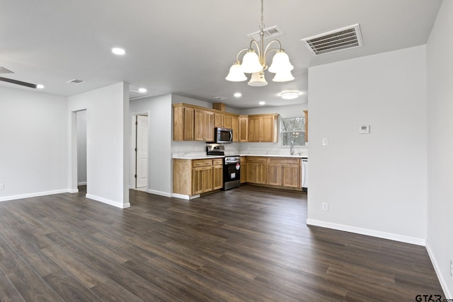 kitchen featuring stainless steel appliances, a sink, visible vents, light countertops, and hanging light fixtures