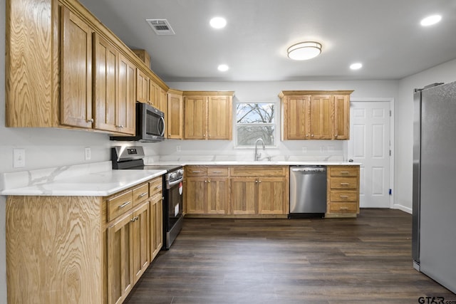 kitchen with a sink, visible vents, light countertops, appliances with stainless steel finishes, and dark wood finished floors