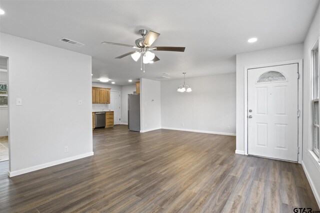 unfurnished living room featuring visible vents, dark wood finished floors, baseboards, and ceiling fan with notable chandelier