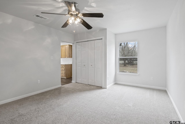 unfurnished bedroom featuring a closet, carpet flooring, visible vents, and baseboards