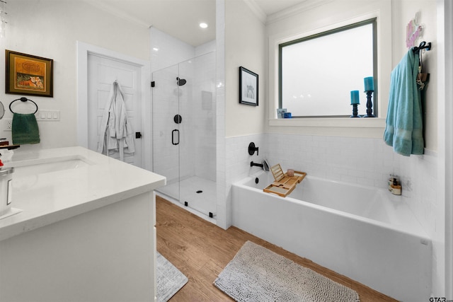 bathroom with wood-type flooring, vanity, separate shower and tub, and ornamental molding