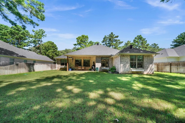 rear view of house featuring a lawn